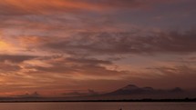 Beautiful Unreal Fire Sunset on The Beach with Volcano Mountains on the background Bali Indonesia Time Lapse Indonesian