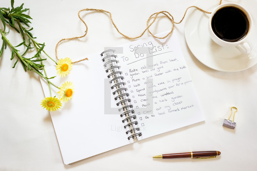 pages in a notebook, pen, clip, coffee cup, twine, spring flower on a white background 