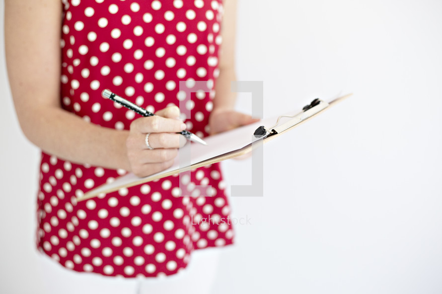 a woman writing on a clipboard 