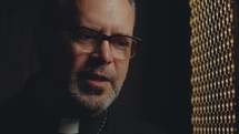 Mature female penitent talking to contemplative priest, he listening attentively and giving advice during confession. Close-up view
