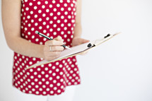 a woman writing on a clipboard 