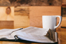An open Bible and a coffee cup.