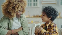 African American Mother and Little Son Sitting at Home and Having Talk
