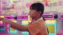 Little girl is playing games at the amusement park
