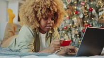 Woman Shopping Online with Laptop at Home before Christmas Day
