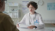 Female Doctor Taking Medical History and Interviewing Patient in Clinic
