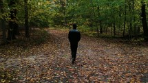 a man walking through a forest 