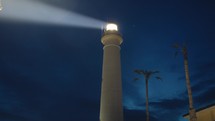 Lighthouse tower in the night with beam light