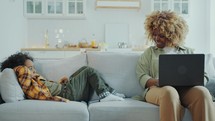 African American Mom Using Laptop and Talking to Little Son at Home
