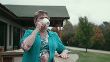 senior woman on a deck with a cup of coffee 