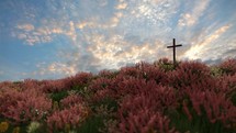 Single cross with pink flowers blowing in the wind.