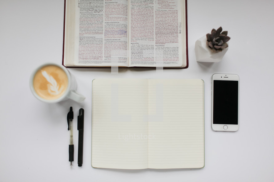 open Bible, field notes book, iPhone, latte, succulent plant, pen, Bible study, white background desk, cup, mug, coffee