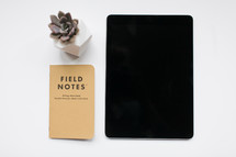 succulent plant, field notes book, and iPad 