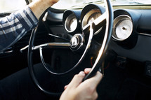 man's hands on a steering wheel