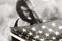 A young woman holding an American flag 