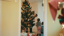 family decorating a Christmas tree 