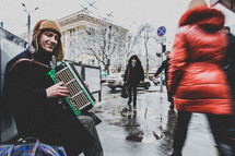 man sitting on a bench playing an accordion