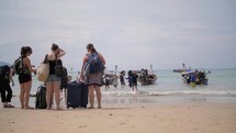 tourists are waiting for boats on a beach in thailand