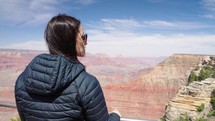 Woman tourist standing at Grand Canyon, enjoying beautiful panoramic view. 
