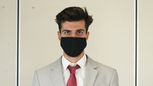 businessman putting on a face mask 
