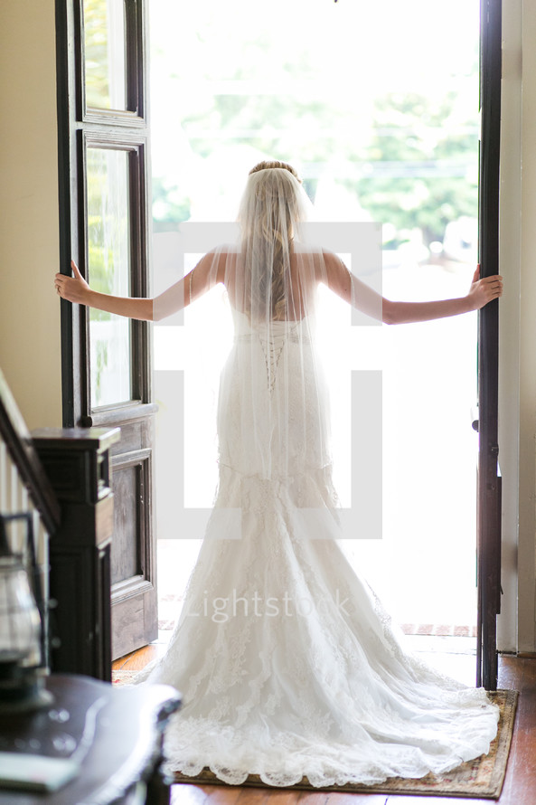 a bride standing in an open doorway 