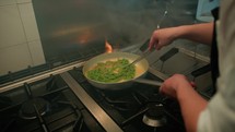 Cooking Green Pesto Tagliatelle Pasta In The Pan Of A Restaurant