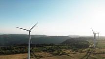 Wind power plant electric generator spinning in the mountains, aerial view