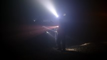 Rescue forces search for survivors inside a dark tunnel using flashlights
