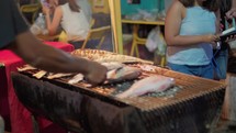 fish are grilled in a night market in bangkok