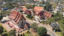 Fly-over survey view of Chalong Temple grounds and shrines in Phuket, Thailand - Aerial Fly-over low angle panoramic shot