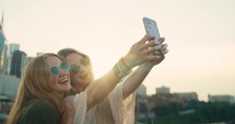 Two young female tourists smile and take selfies in downtown Nashville