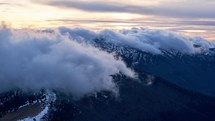 Timelapse of clouds moving over the mountains during twilight. 
