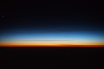 Photograph of a colorful sunrise sky from an airplane windows portraying the beautiful creation of God's heavens, which can be used as a decorative background or wallpaper for church services and bulletins.