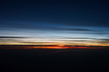 Photograph of a colorful sunrise sky from an airplane windows portraying the beautiful creation of God's heavens, which can be used as a decorative background or wallpaper for church services and bulletins.