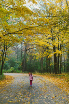 a little girl holding a red fall leaf 