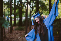 Woman in a graduation gown and hat, celebrating 