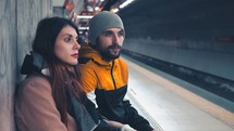 man and woman waiting in a subway 