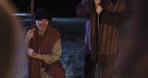 Shepherds kneeling before the manger and baby Jesus