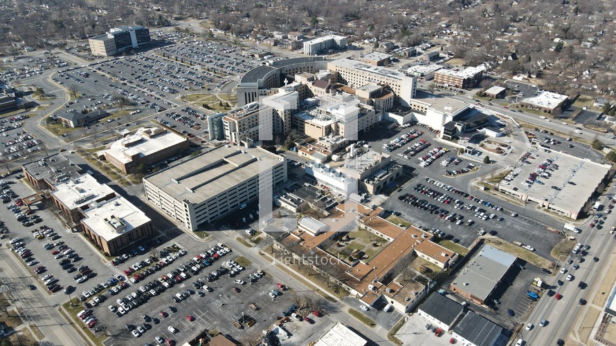 aerial view over parking lots, streets, and buildings in a city 