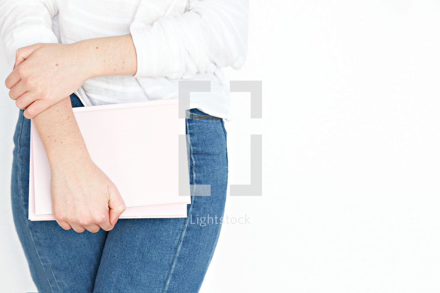 a woman holding a pink notebook 