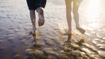 Children Running Through Water On A Sandy Beach In Beautiful Summer Sun