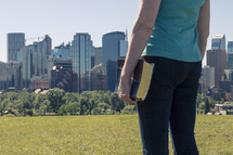 Woman with Bible and City Skyline 
