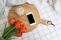 muffin, tulips, cellphone, and cutting board 