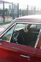 fuzzy dice hanging in a vintage red car 