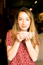a woman in a red dress holding a coffee mug 