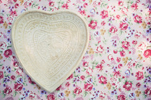 heart shaped plate on floral wallpaper 