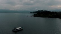 Passenger Boat At Lake Atitlan, Guatemala During Sunrise - aerial pullback	