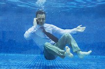 Businessman on the phone underwater