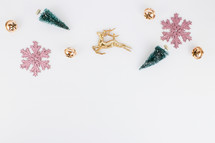 pink and gold Christmas ornaments and bottle brush Christmas trees on white 