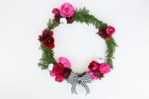 flowers and pine with bow on Christmas wreath 